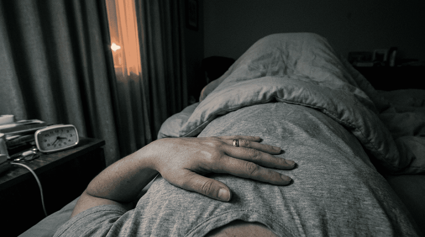 A hand resting on the chest in a dark bedroom at 2:40 a.m., heart palpitations in perimenopause.