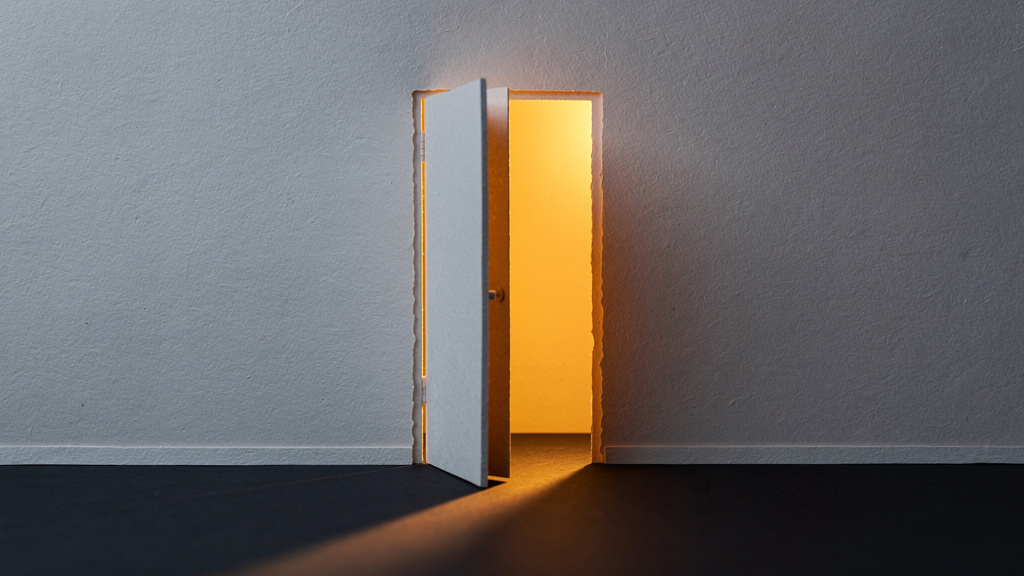 A cut-paper illustration of a door slightly ajar in a hallway, warm golden light spilling through the narrow gap