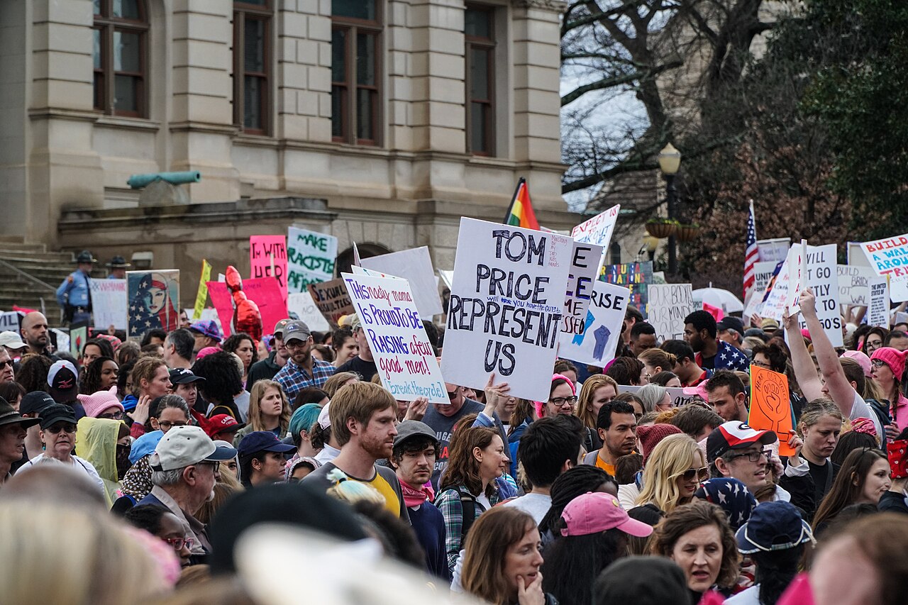 Women carrying handwritten signs at a march in 2017, the same act as 1970 with the placards written overnight